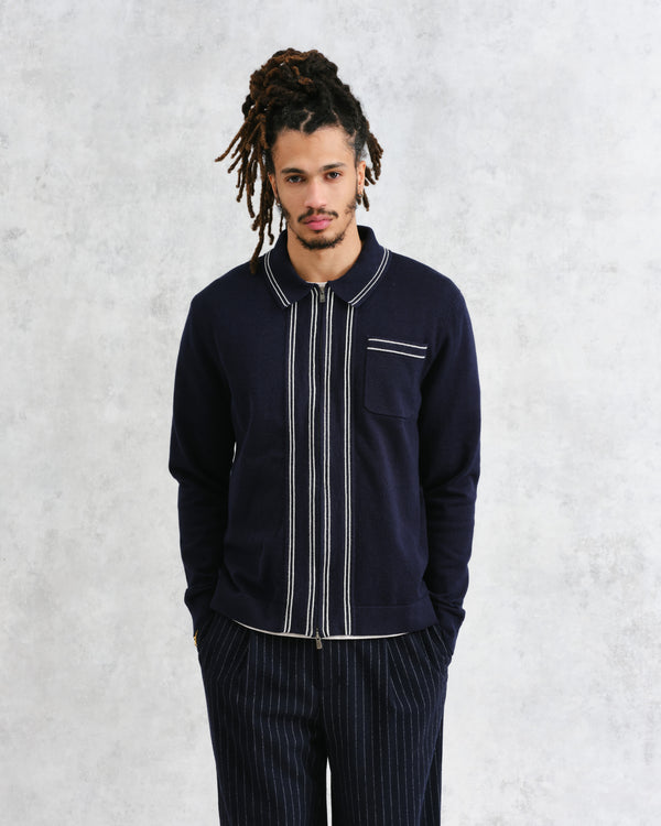 model facing front wearing wax london navy milano knit long sleeve polo