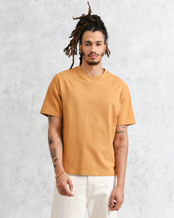 model facing front wearing mustard textured organic cotton t-shirt