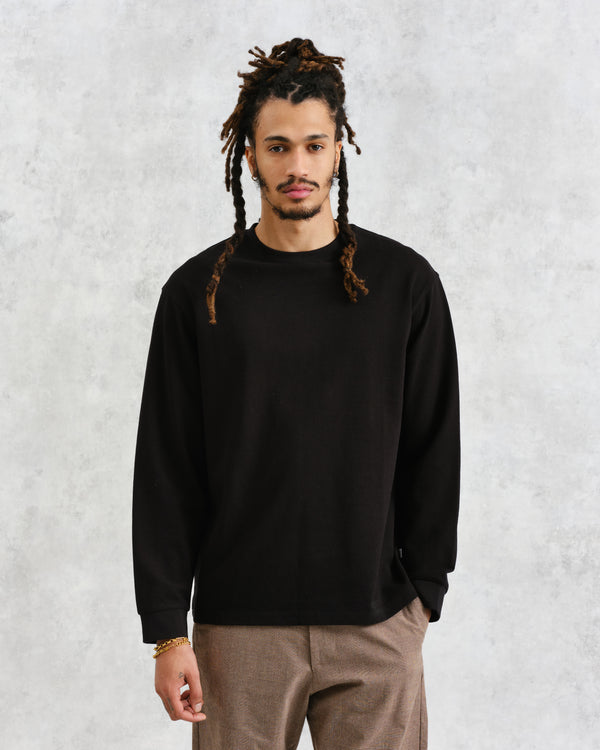 model facing front wearing wax london black textured organic cotton long sleeve t-shirt