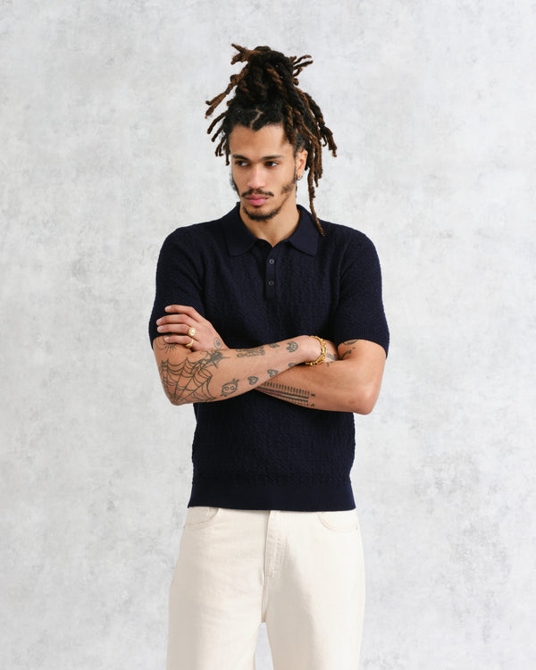 model facing front wearing wax london navy textured check knitted polo shirt